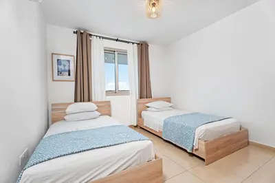 two beds in a room with a window at Spitaki 2 BDR Apartment with Pool and Close Proximity to Beach in Paralimni