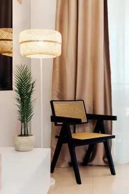 a black chair next to a potted plant and a lamp at Spitaki 2 BDR Apartment with Pool and Close Proximity to Beach in Paralimni