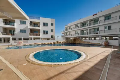 a large swimming pool in front of a building at Spitaki 2 BDR Apartment with Pool and Close Proximity to Beach in Paralimni