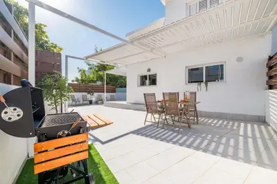 a patio with a grill and a table and chairs at Napa Centro Apartment in Ayia Napa