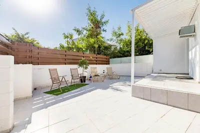 a patio with chairs and tables and a fence at Napa Centro Apartment in Ayia Napa