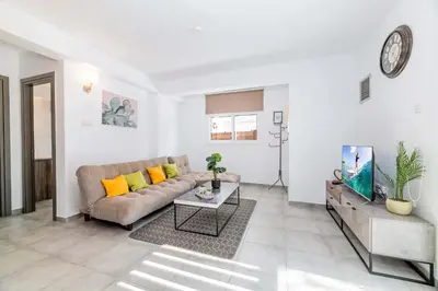 a living room with a couch and a tv at Napa Centro Apartment in Ayia Napa
