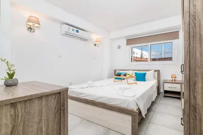 a bedroom with a bed and a desk in it at Napa Centro Apartment in Ayia Napa