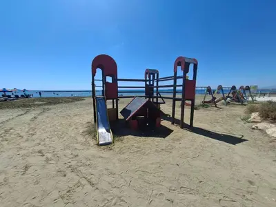 a playground in the sand on a beach at Seaside Escape Apartment in Larnaka