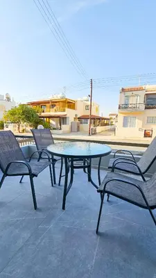 a table and two chairs and a table and a table at La Magenta Apartments in Pyla