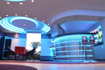 a room with a blue stage with a table and chairs at Vassos Nissi Plage Hotel & Spa in Ayia Napa