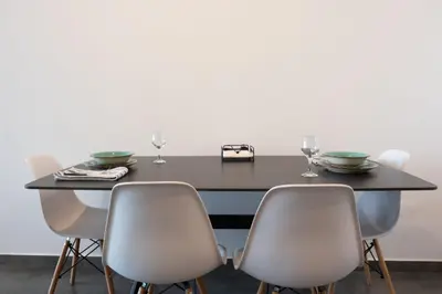 a dining room table with four chairs and wine glasses at Luxurious two bedroom apartment with roof garden in Kato Lakatamia