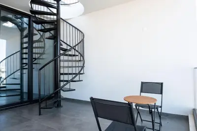 a spiral staircase in a room with a table and chair at Luxurious two bedroom apartment with roof garden in Kato Lakatamia