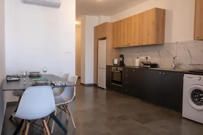 a kitchen with a table and chairs in a room at Luxurious two bedroom apartment with roof garden in Kato Lakatamia