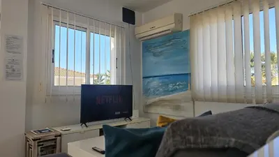 a living room with a television and a bed at STAY Villa Harsha in Ayia Napa