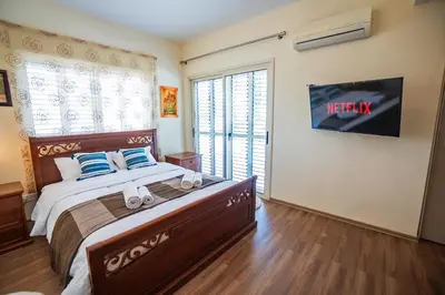 a bedroom with a bed and a tv on the wall at Beachfront Villa Larnaka Dhekelia with Pool in Pyla