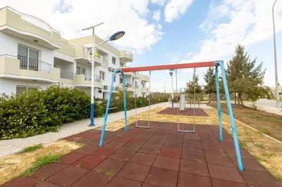 an empty playground in front of a building at Obv 2304 in Pyla
