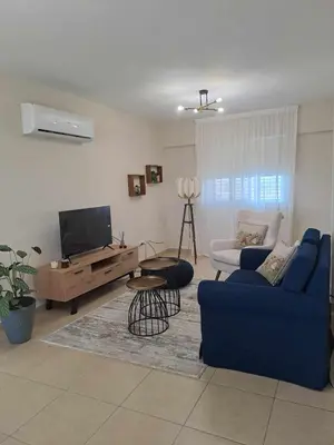 a living room with a blue couch and a tv at Blue Boutique Flat in Larnaka