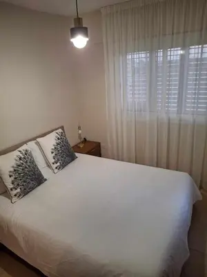 a bedroom with a large white bed with a window at Blue Boutique Flat in Larnaka