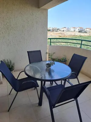 a glass table and chairs on a patio with a view at Blue Boutique Flat in Larnaka