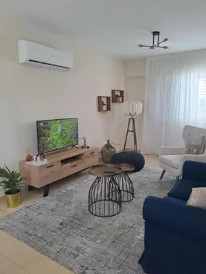 a living room with a television and a table and chairs at Blue Boutique Flat in Larnaka