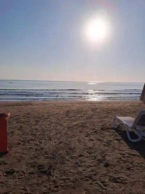 a beach chair sitting on the sand on the beach at Blue Boutique Flat in Larnaka