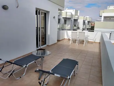 a balcony with a table and chairs on a building at Oceania Bay Residence in Pyla