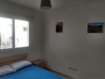 a bedroom with a blue bed and a window at Oceania Bay Residence in Pyla