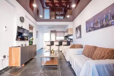 a living room with a white couch and a table at Mackenzie Suite in Larnaka