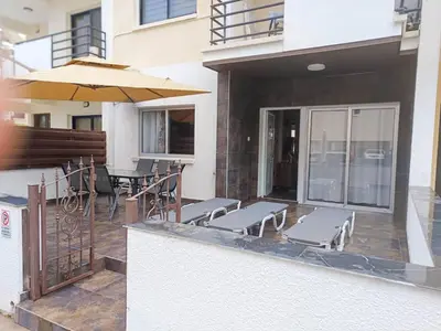 a patio with a table and chairs and an umbrella at Mackenzie Suite in Larnaka