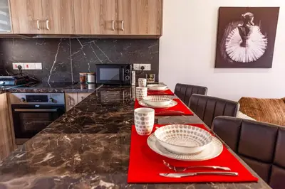 a kitchen with a table with red napkins on it at Mackenzie Suite in Larnaka