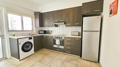 a kitchen with a washer and a white refrigerator at Blue Sky Ocean Retreat in Larnaka