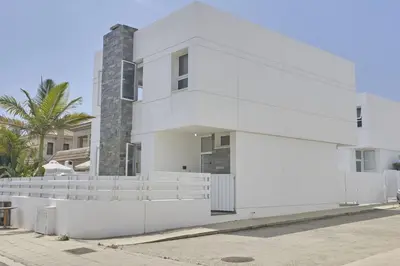 a white building with a palm tree in the background at Protaras Pearl Villa Pe15 in Protaras