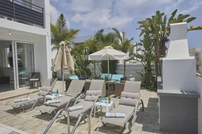 a patio with chairs and a table and an umbrella at Protaras Pearl Villa Pe15 in Protaras