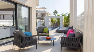 a patio with chairs and a table on a building at Nissi Residences Villa 4 in Ayia Napa