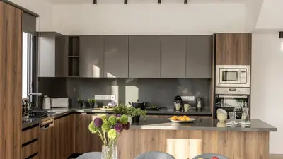 a kitchen with gray cabinets and a counter top at Nissi Residences Villa 4 in Ayia Napa