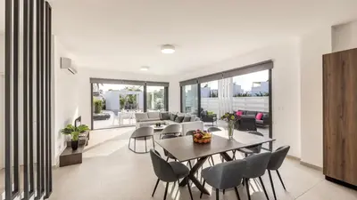 a dining room and living room with a table and chairs at Nissi Residences Villa 4 in Ayia Napa