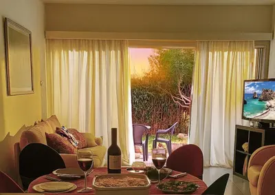 a living room with a couch and a table with wine glasses at Sea view Beach House with Pool in Limassol