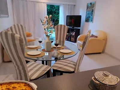 a dining room with a table and chairs and a television at Sea view Beach House with Pool in Limassol