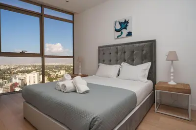 a bedroom with a large bed with two towels on it at 360 Sky Residence, Gym & Pool - 26th Floor in Nicosia