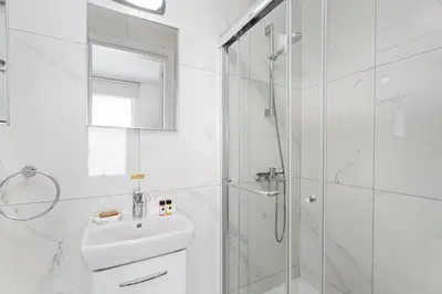 a white bathroom with a sink and a shower at Serene Villa Retreat in Protaras in Paralimni