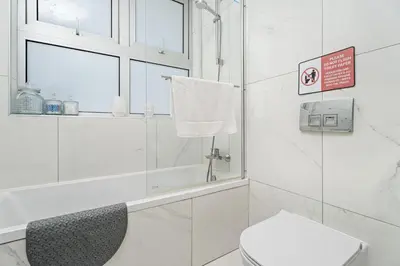 a white bathroom with a shower and a toilet at Serene Villa Retreat in Protaras in Paralimni