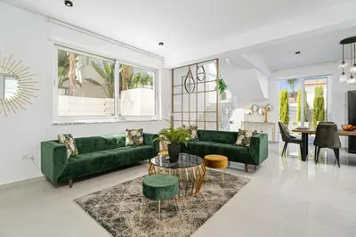 a living room with green couches and a table at Serene Villa Retreat in Protaras in Paralimni