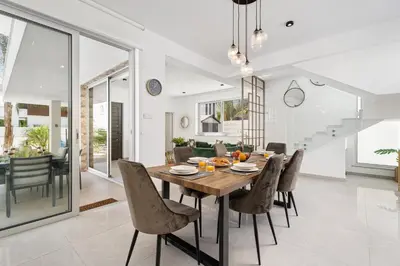 a dining room with a wooden table and chairs at Serene Villa Retreat in Protaras in Paralimni