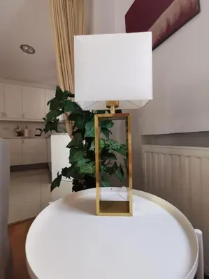 a lamp on top of a white table with a plant at Cozy Family Home in Laxia