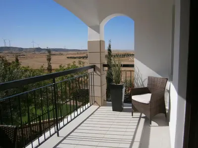 a balcony with a chair and a view of the countryside at Emerald Heights in Tersephanou
