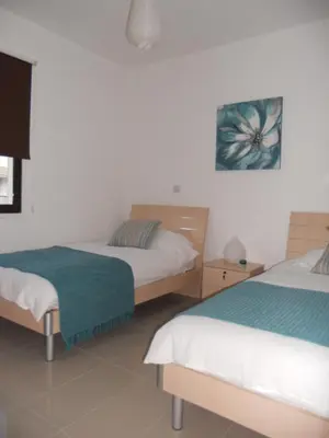 a bedroom with two beds and a painting on the wall at Emerald Heights in Tersephanou