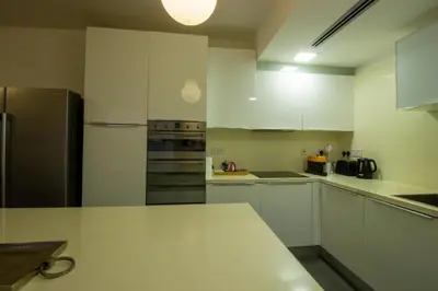 a kitchen with white cabinets and stainless steel appliances at Top Floor Gem: 3BR, Huge Veranda in Nicosia