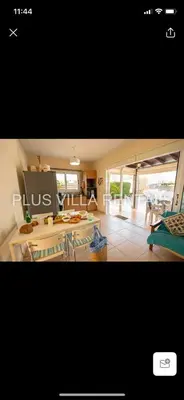 a kitchen and living room with a table and chairs at Villa 4 Ayia Thekla in Ayia Napa