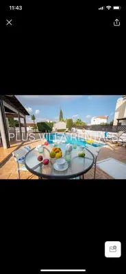a table with a plate of fruit next to a swimming pool at Villa 4 Ayia Thekla in Ayia Napa