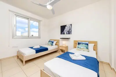 a bedroom with two beds and a window at Konnos Breeze Villa in Protaras