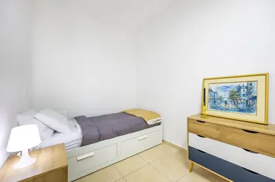 a small bedroom with a bed and a dresser at Agios Tychon Luxury Villa with Private Pool in Limassol