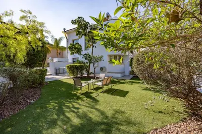 a garden with two chairs and a table in a yard at Agios Tychon Luxury Villa with Private Pool in Limassol