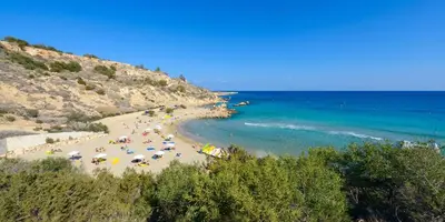 a beach with a bunch of people and the ocean at Villa Atlantis in Protaras