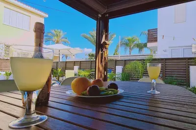 a table with two glasses of wine and fruit on it at Casa Palmera in Paralimni